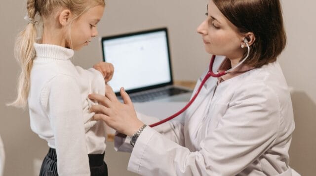 Ilustrasi. Seorang dokter meeriksa kesehatan pernafasan seorang anak dengan alat kesehatan. Foto oleh Pavel Danilyuk: