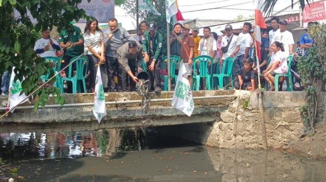 Nefri Izha Mahendra Bacaleg DPR Kota Tangerang dari PKB saat menebar ikan lele di irigasi Sipon. Foto : Eky Fajrin