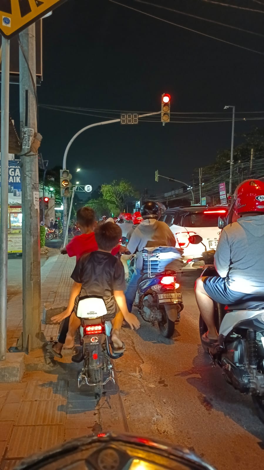 Dua orang anak menggunakan sepeda listrik di jalan raya ditengah padatnya kendaraan roda dua dan empat di jalan KH> Hasyim Ashari Kota Tangerang, Banten.