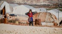 Seorang anak berdiri di kawasan pengungsian di Palestina. FOTO : oleh Ahmed akacha: