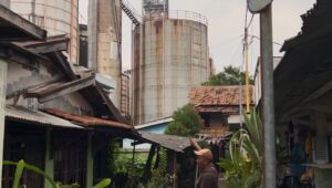 Warga setempat menunjukan cerobong asap pabrik